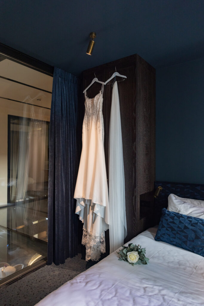 Luxury Fine Art trouwfotografie trouwjurk hangend in sfeervolle hotelkamer voor de bruiloft
